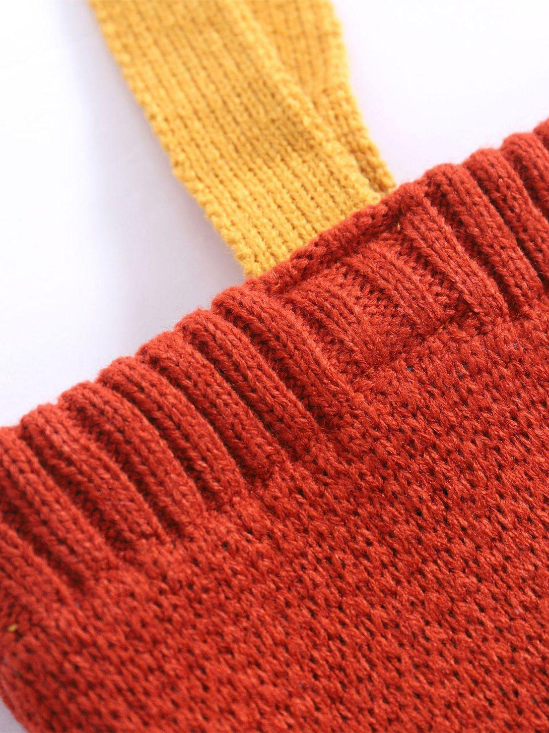 Zoomed-in texture of TALISHKO's knit bag, showcasing the vibrant red and yellow stitching.