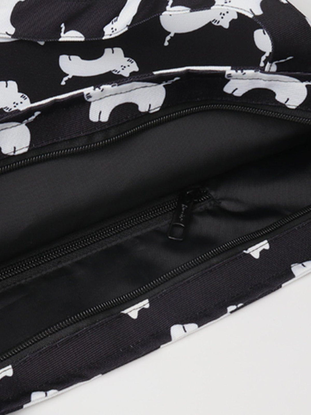 Intricate look at TALISHKO's black canvas shoulder bag, showcasing playful white cat prints.