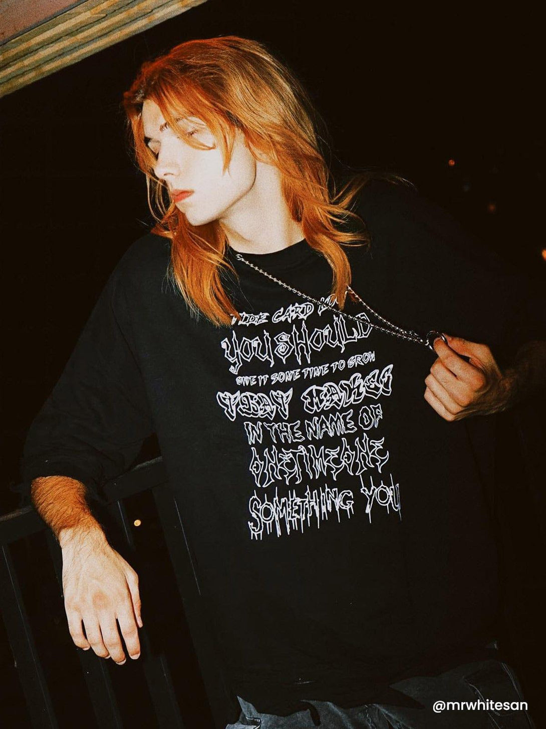 Model in a TALISHKO distressed tee with chain detail, capturing a cool and edgy night vibe.