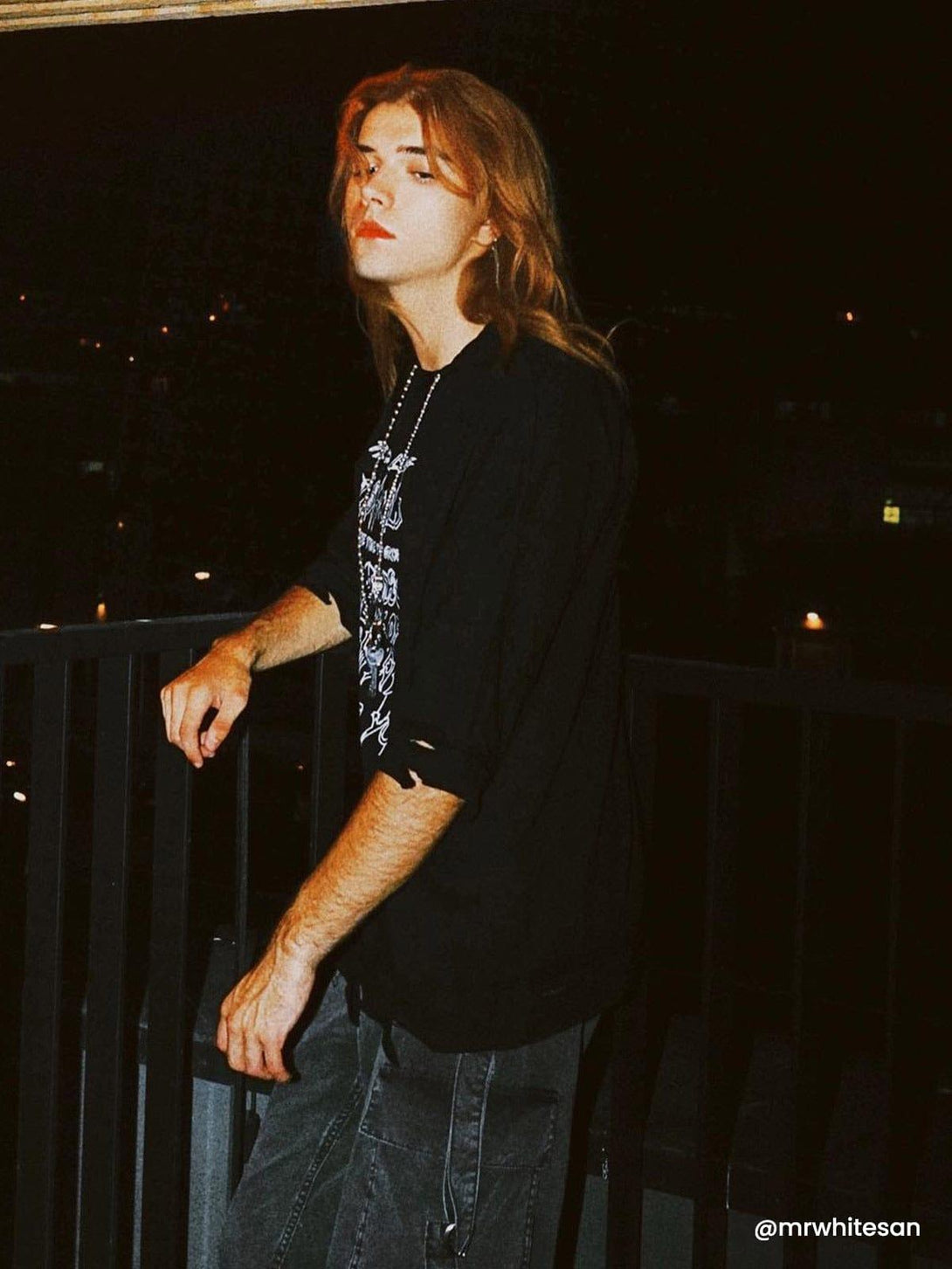 Model poses in a TALISHKO distressed tee with chain detail, embodying urban summer style.