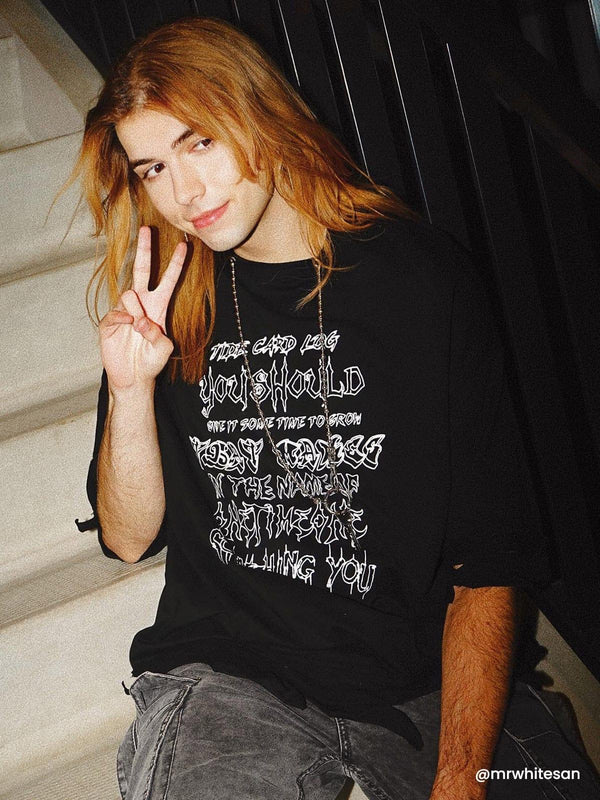 Model wearing a black distressed tee with chain detail by TALISHKO, perfect for casual vibes.