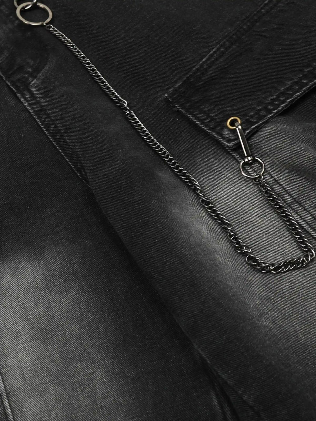 Intricate look at TALISHKO cargo jeans, highlighting chain detail and pocket stitching.