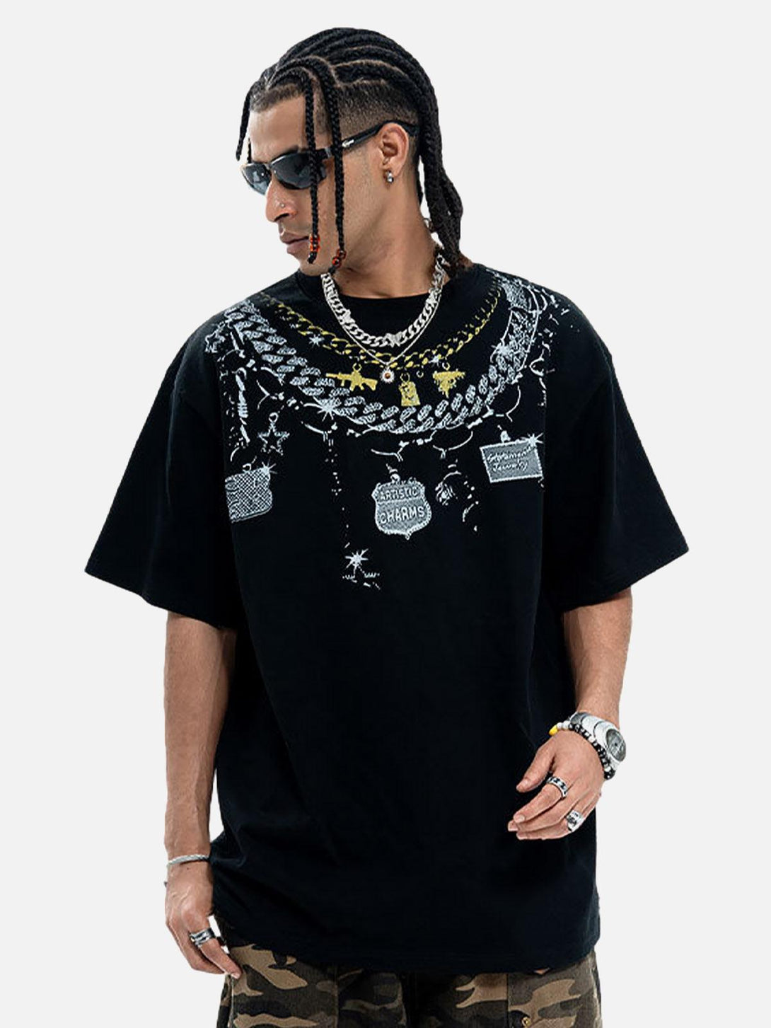 Model in black chain print crew neck T-shirt by TALISHKO, paired with camo pants and accessories.