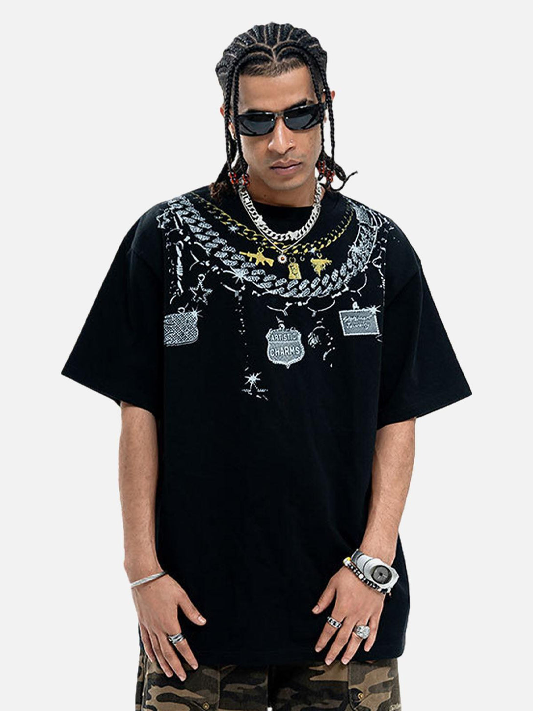 Model sporting a TALISHKO chain print T-shirt, paired with camo pants and bold accessories.