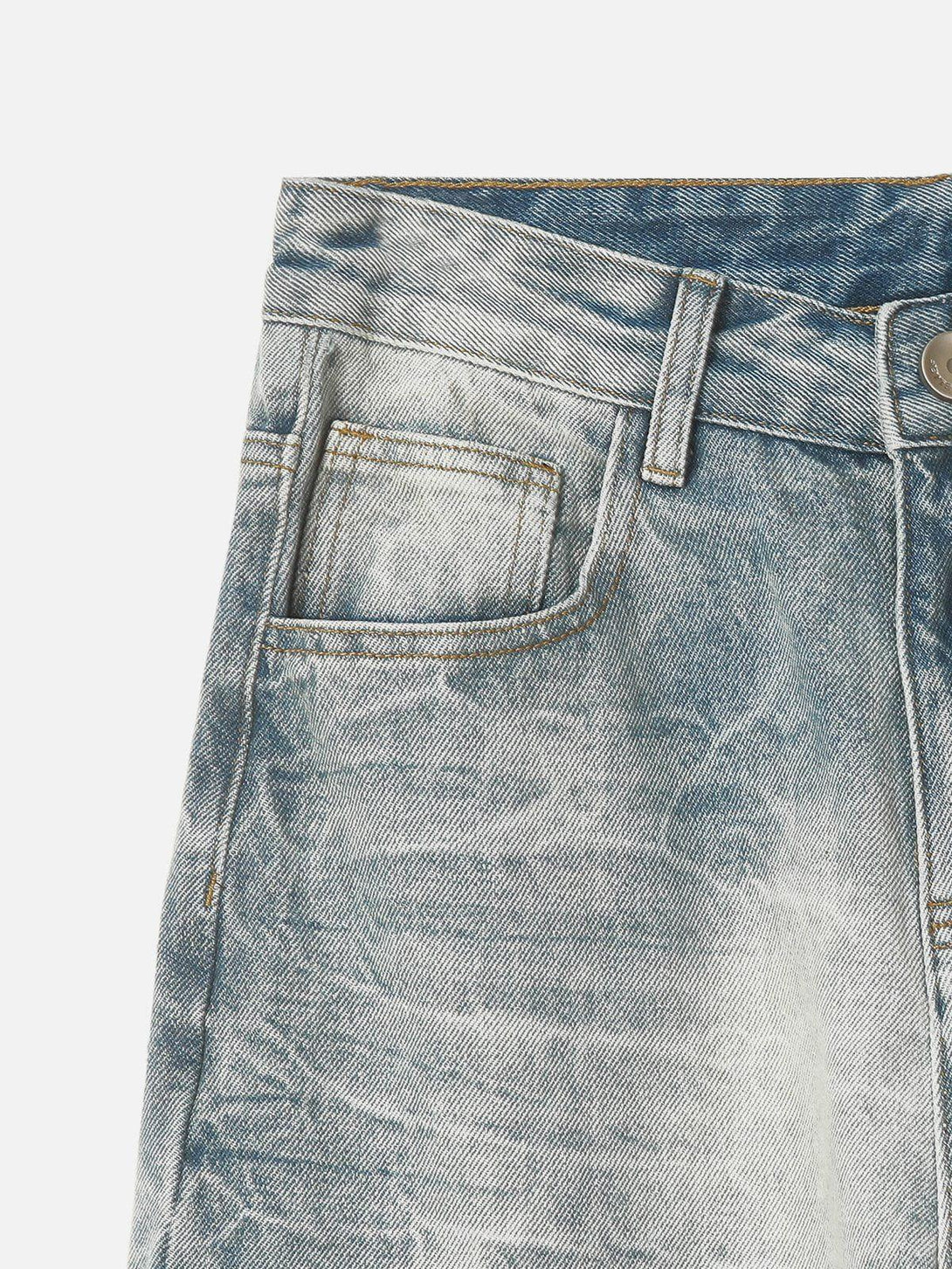 Intricate look at TALISHKO's washed graphic jeans, highlighting unique texture and chain detail.