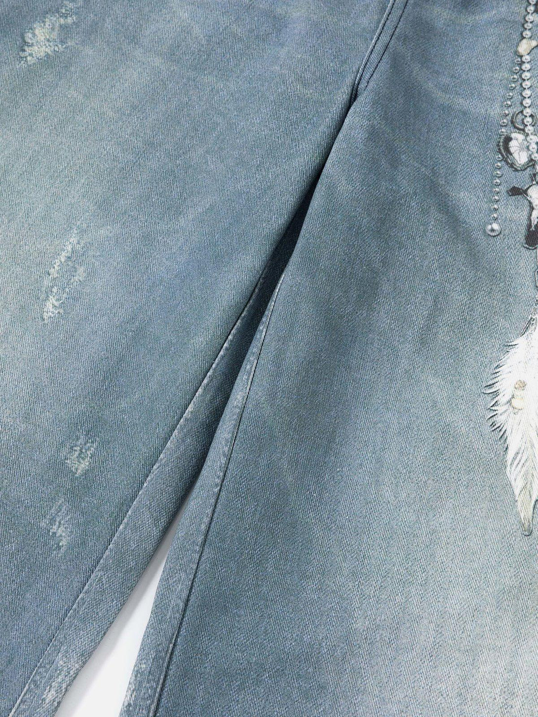 Intricate fabric and chain print detail on TALISHKO jeans, showcasing unique design elements.