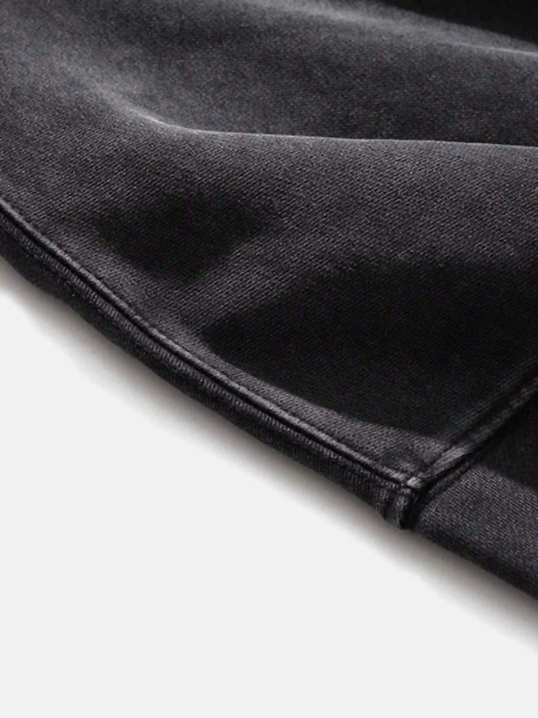 A close-up of dark fabric on a TALISHKO hip-hop hoodie, showcasing its rugged texture.