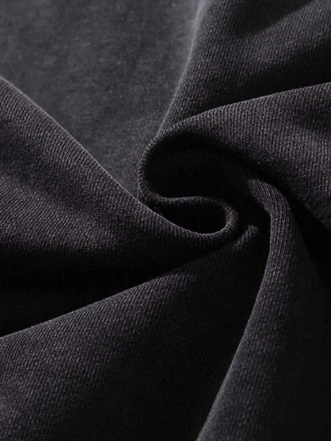 Zoomed-in texture of black fabric on a TALISHKO hoodie, showcasing its rugged style.