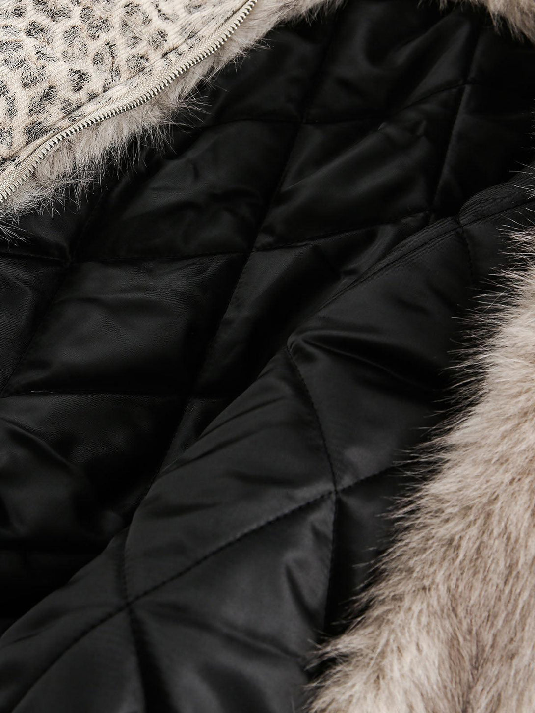 Detailed view of the quilted interior and mink fur trim on TALISHKO's cheetah print jacket.