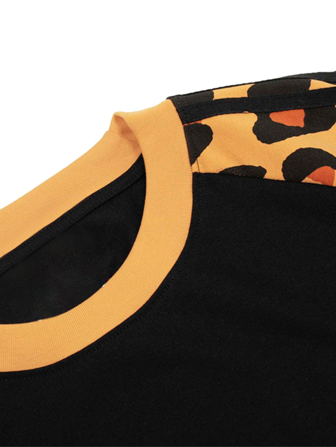 A detailed look at the cheetah print and stitching on a raglan sleeve T-shirt by TALISHKO.