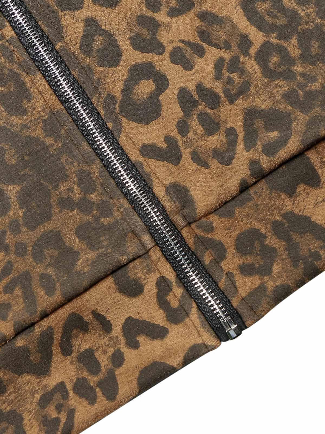 A detailed view of TALISHKO cheetah print suede pants highlighting the zipper and pattern.