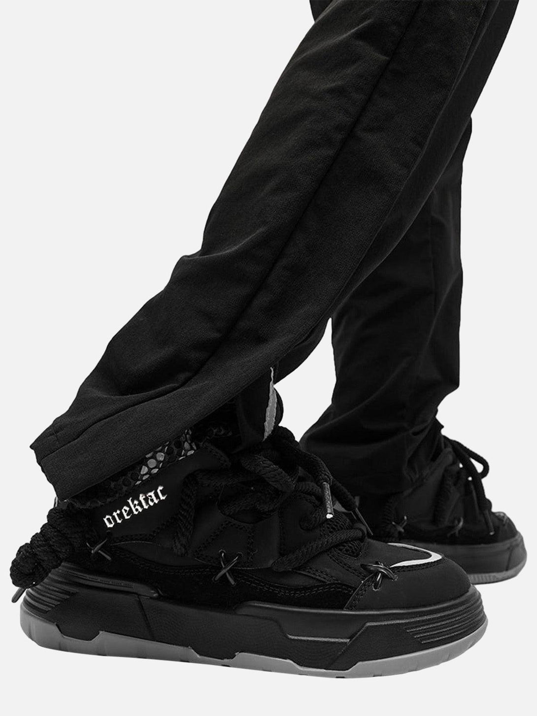 Model in black pants wearing chunky rope shoes by TALISHKO, highlighting unique urban style.