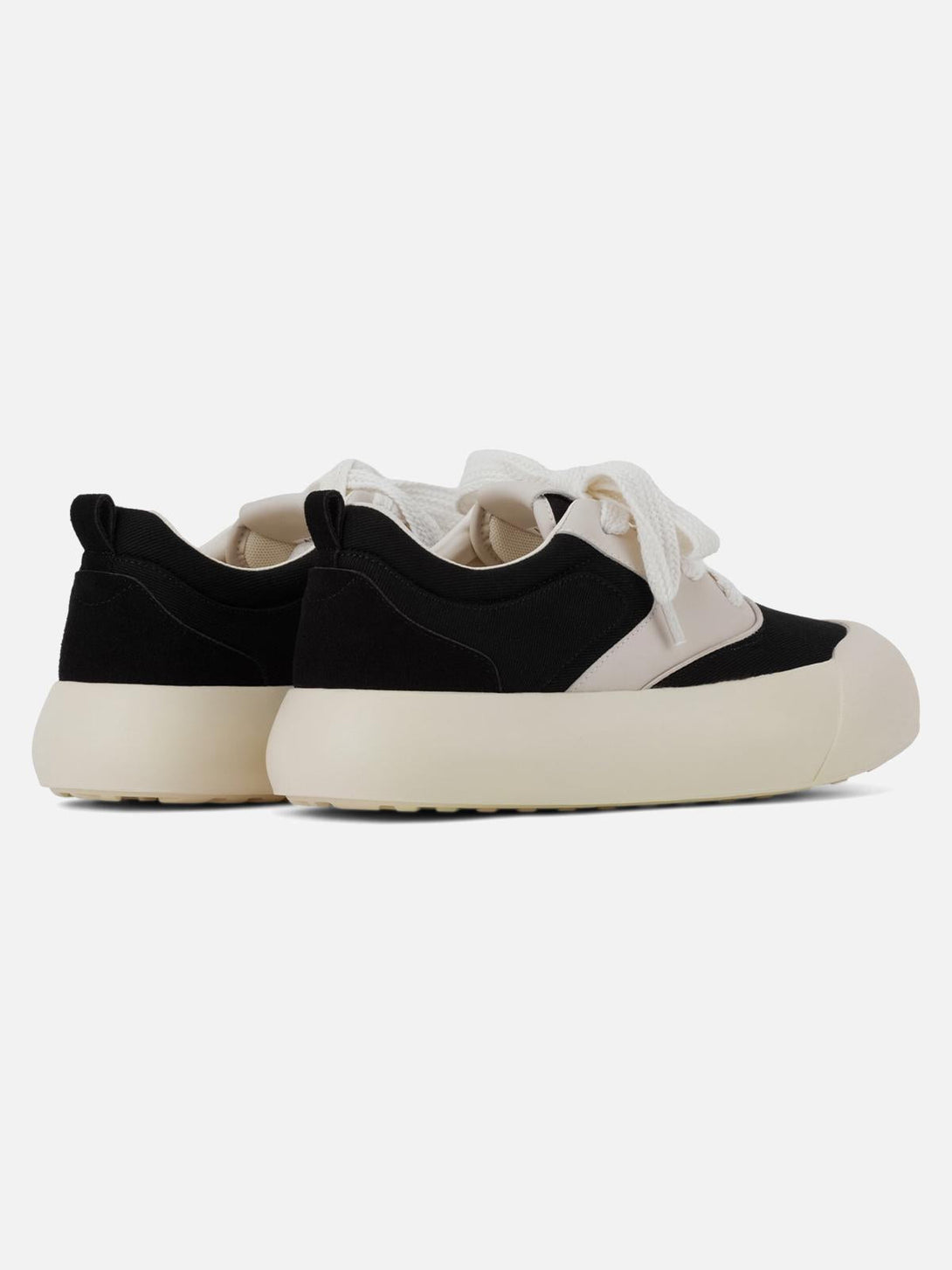 Back view of TALISHKO's chunky round-toe sneakers showcasing a stylish black and cream design.