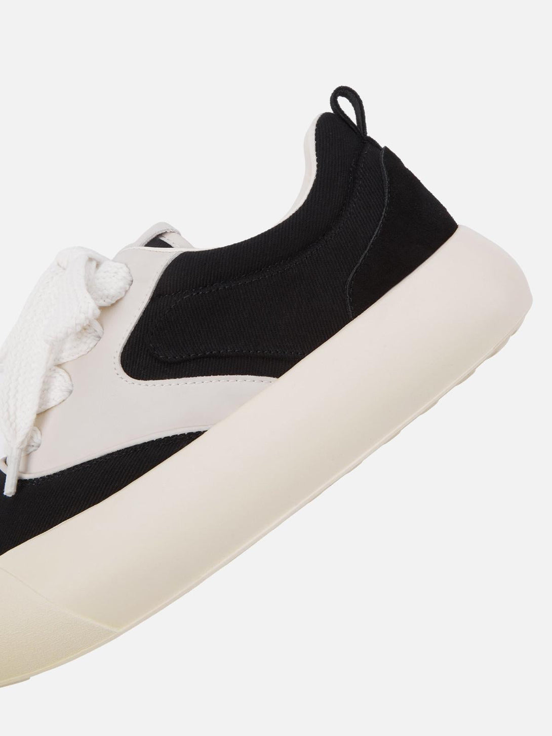 Detailed view of TALISHKO's chunky sneakers, highlighting the black and cream color-block design.