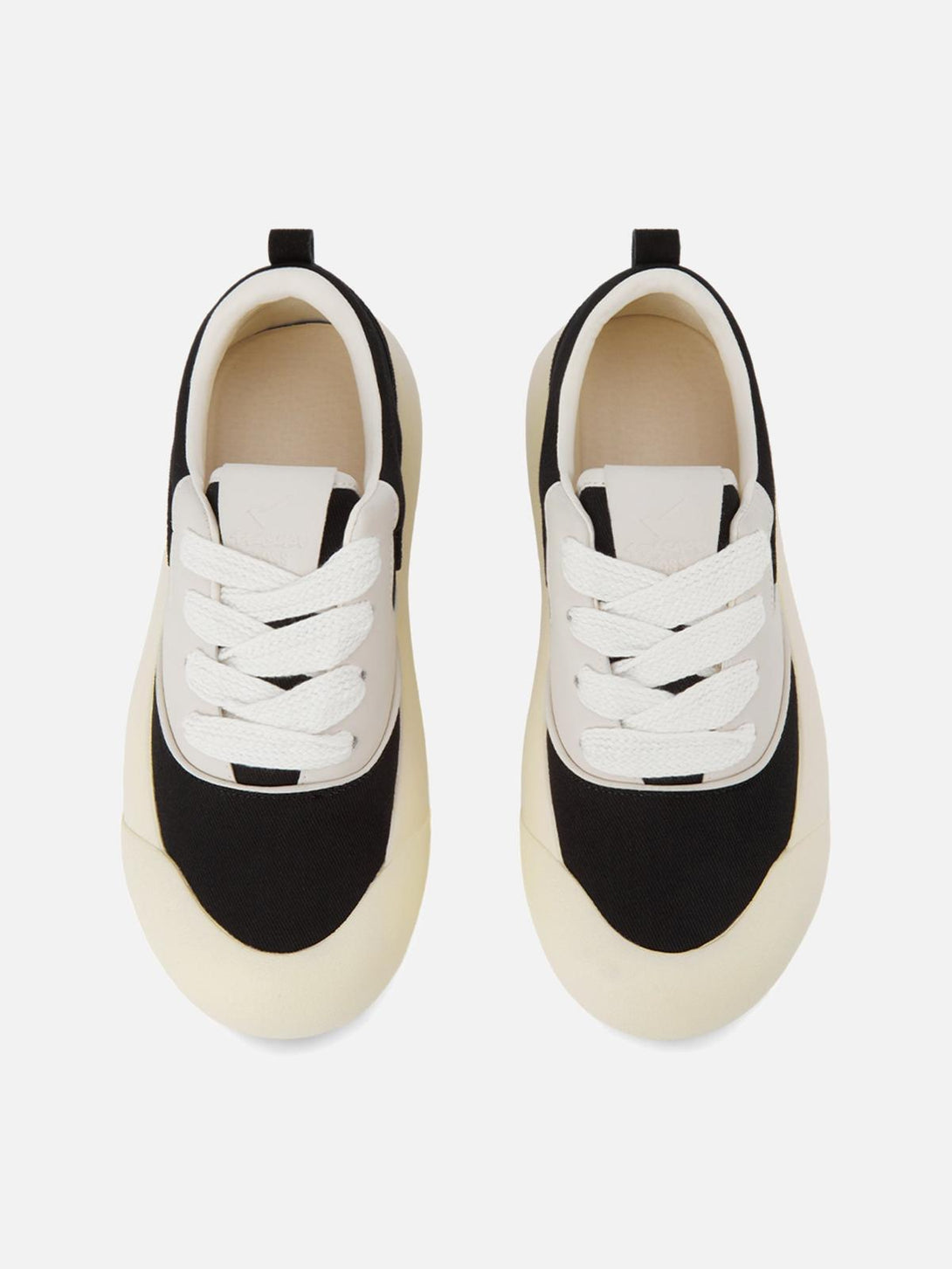 Top view of TALISHKO's chunky round-toe sneakers in a sleek black and cream color-block design.