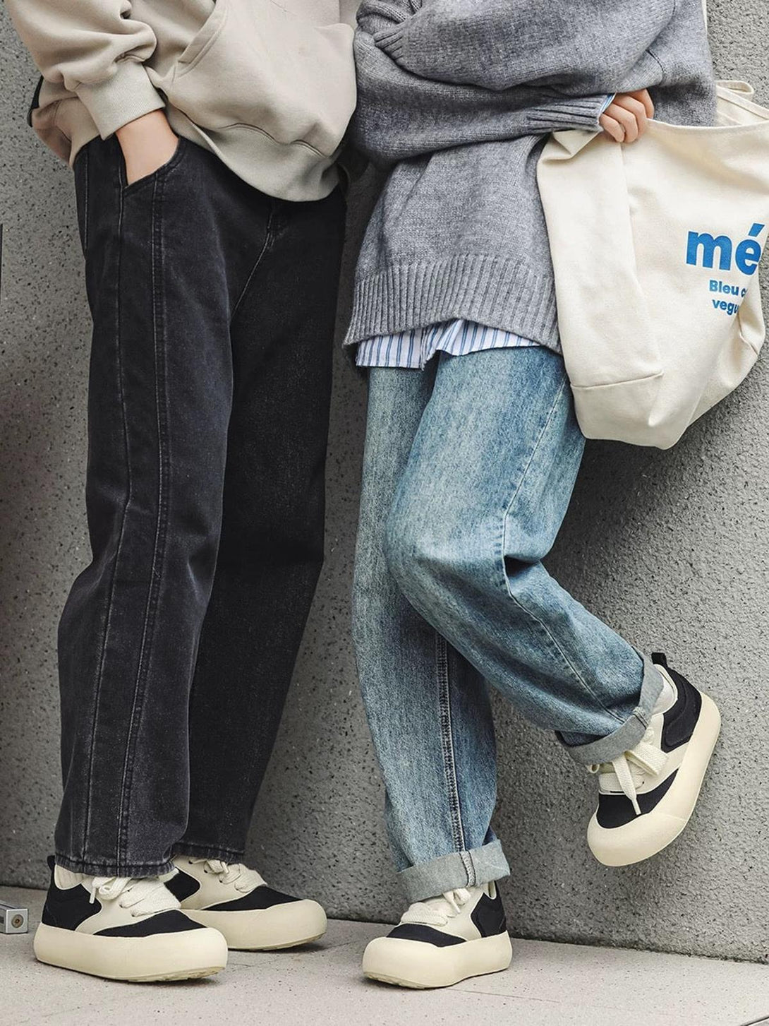 Two people wearing TALISHKO's chunky sneakers in a black and cream color-block style.