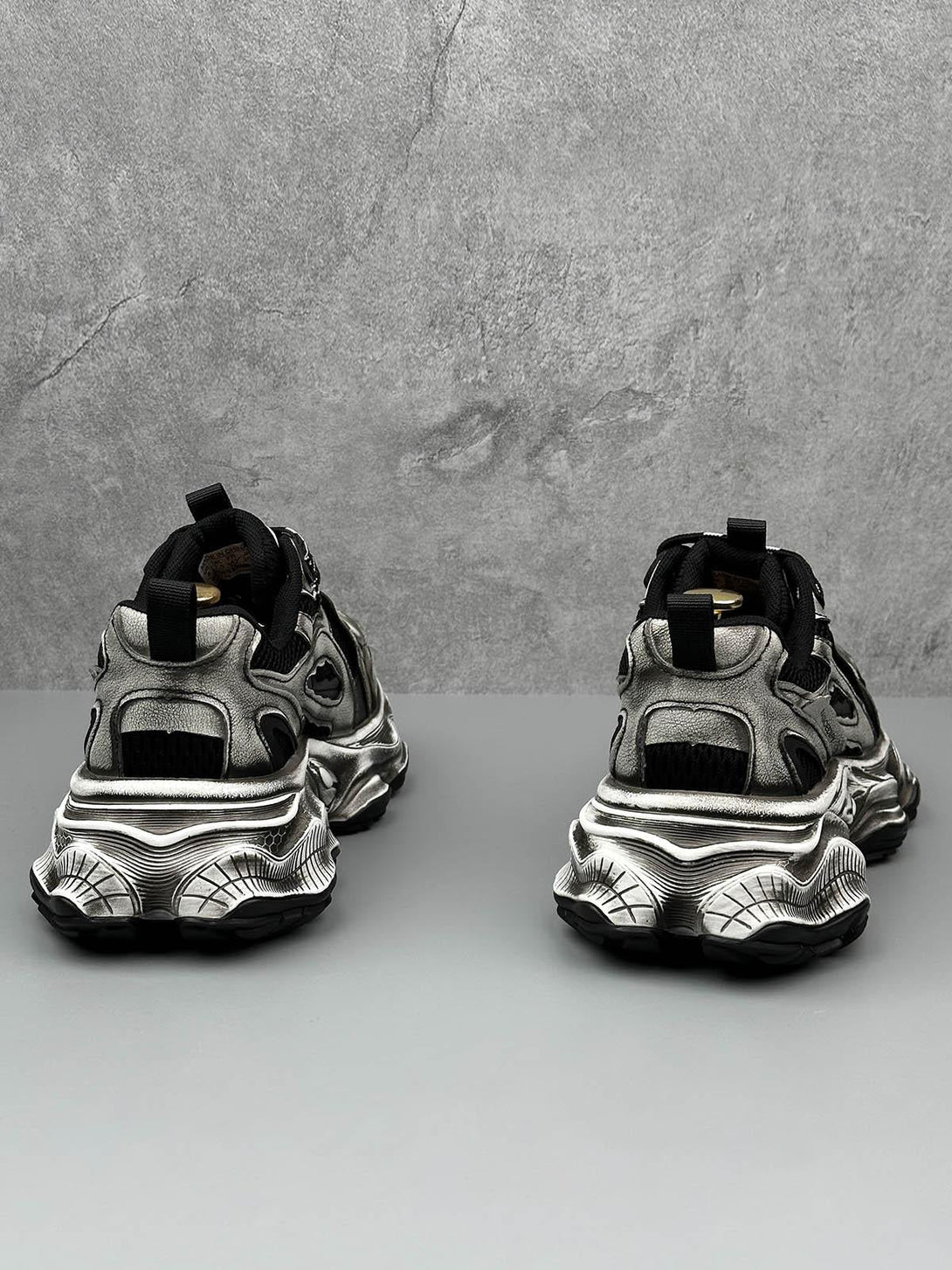 Rear view of TALISHKO chunky sole sneakers in metallic, highlighting bold design elements.