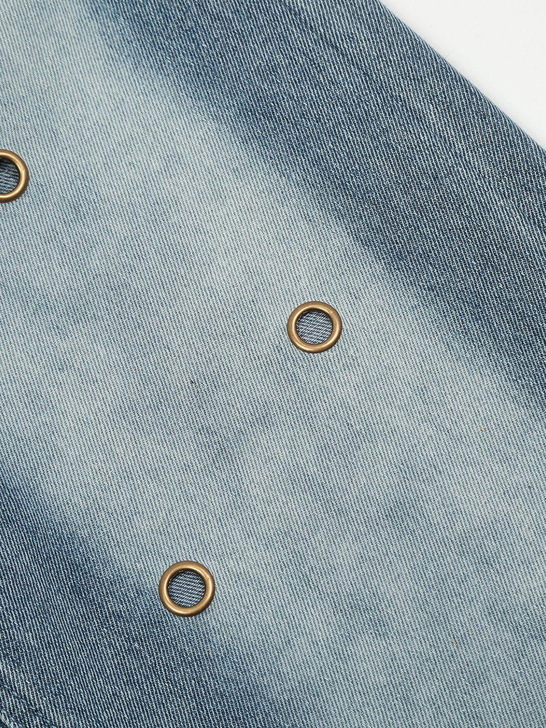 Intricate look at TALISHKO jeans, showcasing unique circle cut-outs and textured denim design.
