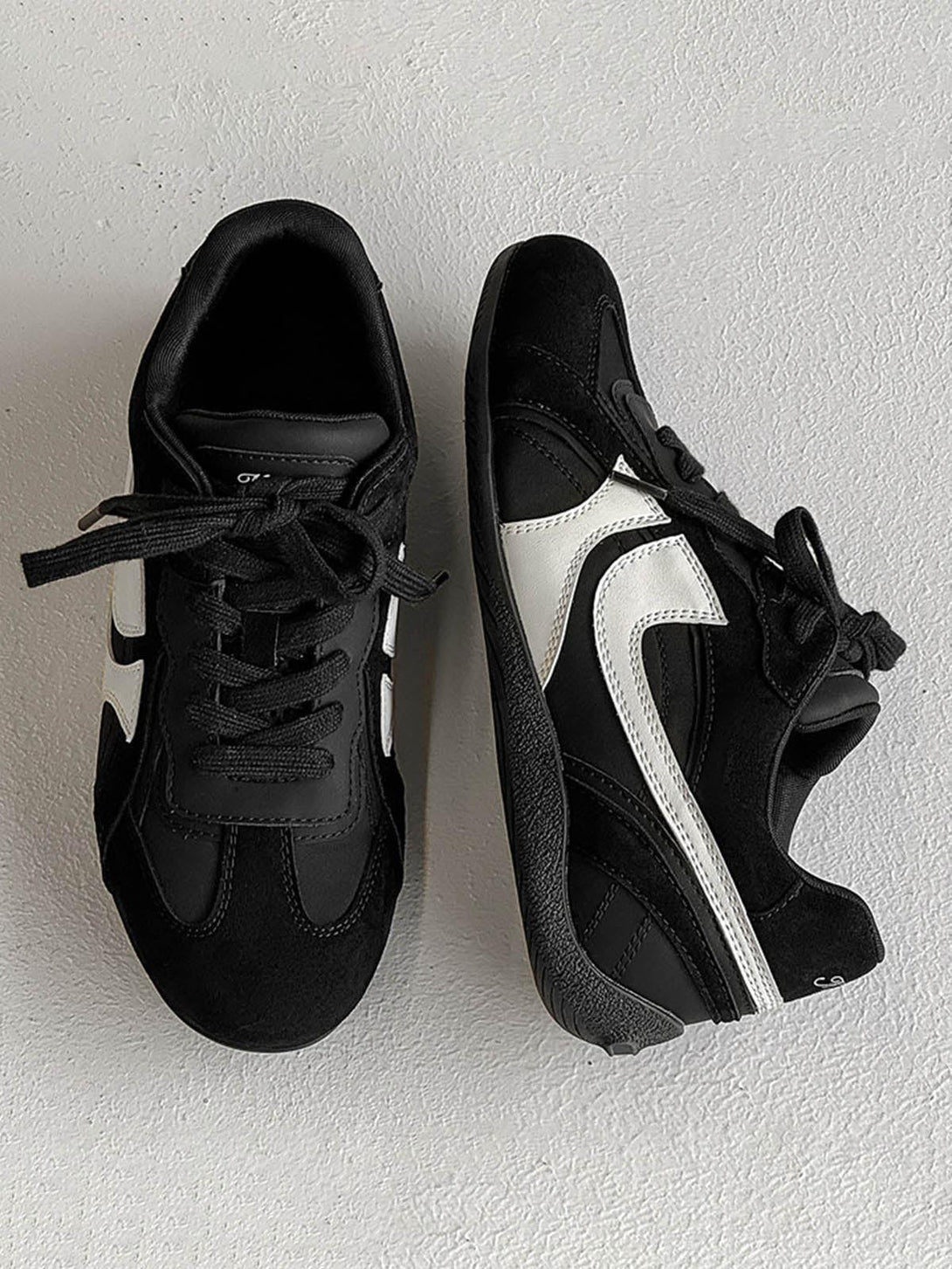 TALISHKO classic black suede low-top sneakers with white details, viewed from above.