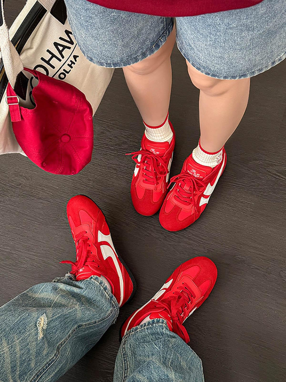 TALISHKO red suede low-top sneakers paired with denim, showcasing a casual street style look.