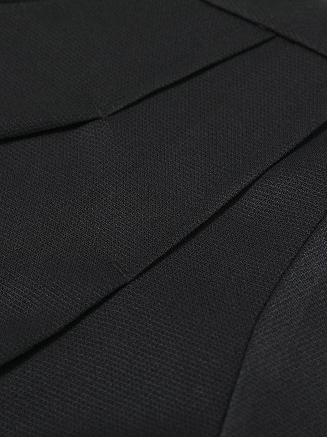 A detailed view of the black pleated fabric on a T-shirt by TALISHKO, highlighting its texture.