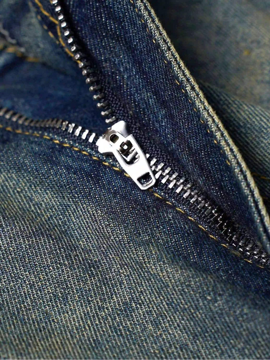 Focusing on the zipper detail of TALISHKO denim jorts, showcasing intricate craftsmanship.