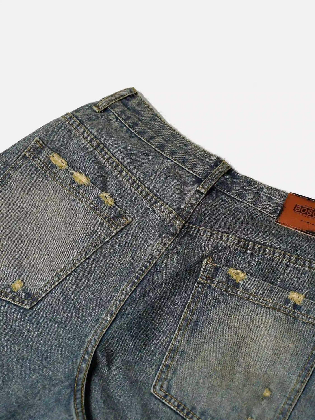 Back view of TALISHKO denim jorts highlighting distressed details and patchwork accents.