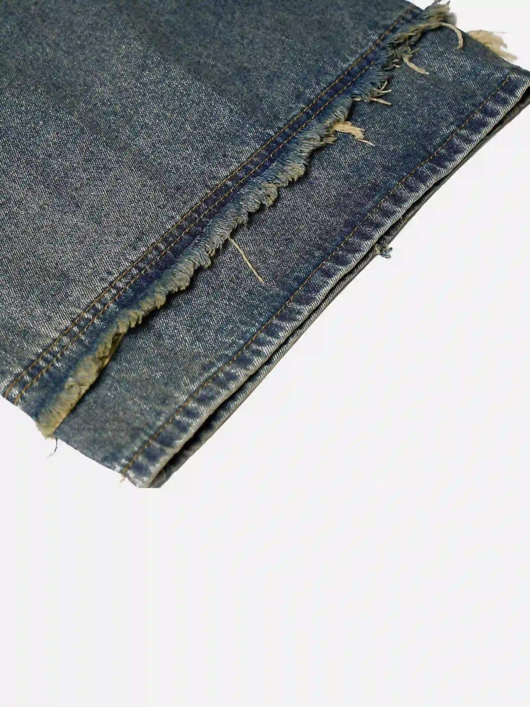 Detailed fabric and frayed hem of TALISHKO denim jorts, highlighting a rugged texture.