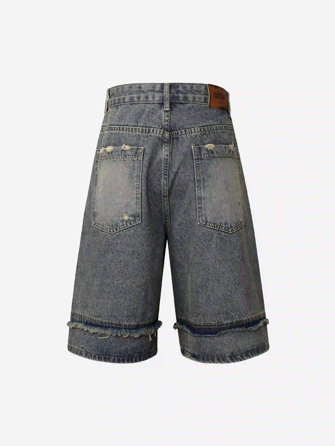 Back view of TALISHKO cropped denim jorts showcasing distressed details and patchwork accents.