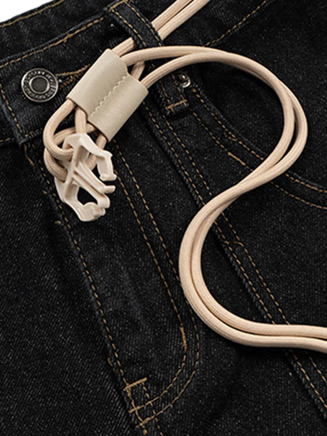 A detailed view of TALISHKO's buckle belt on black baggy jeans, highlighting unique design elements.