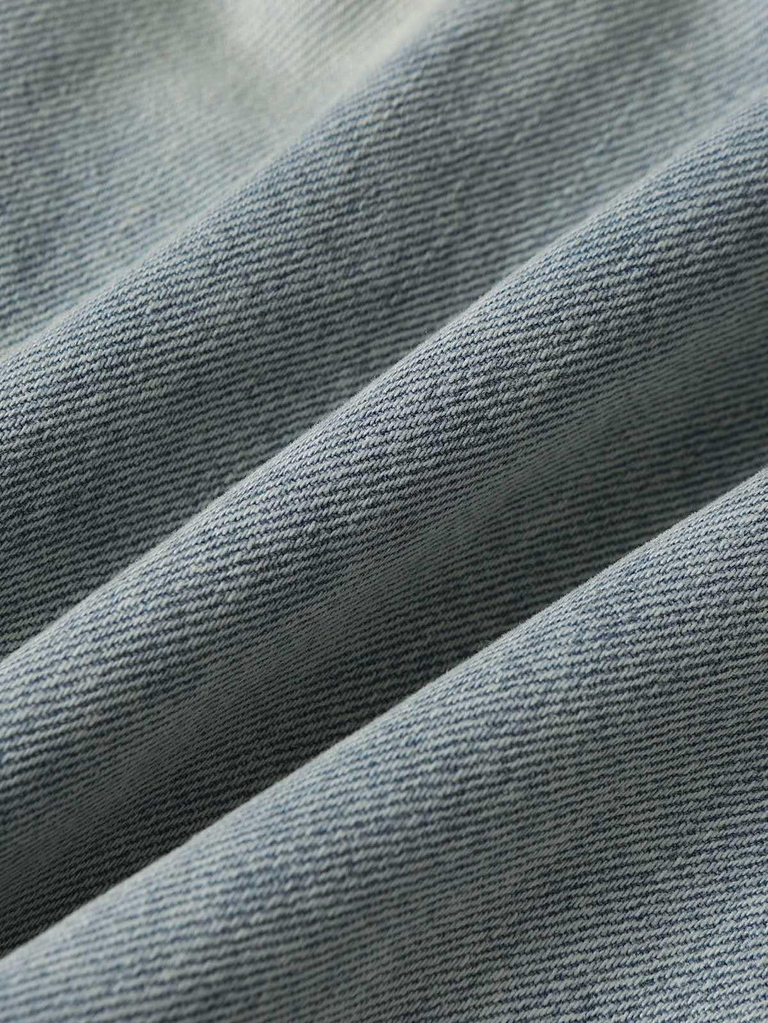 Zoomed-in texture of TALISHKO's denim, highlighting the detailed weave of baggy cargo jorts.
