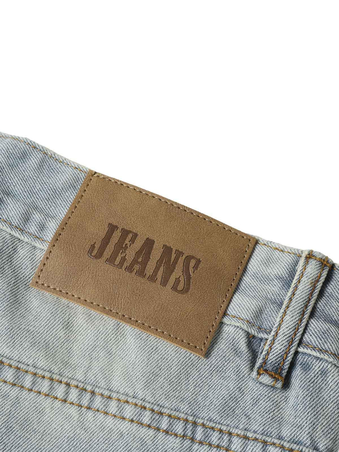 A close-up of TALISHKO's denim label on baggy cargo jorts, emphasizing casual summer style.