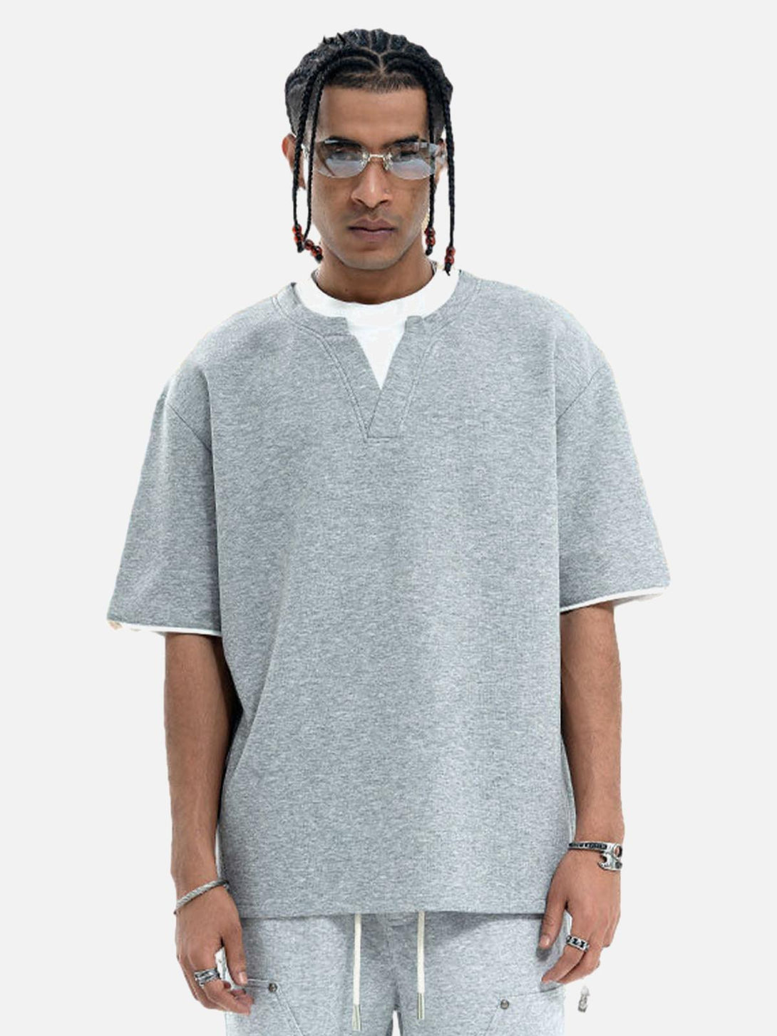 Model in a TALISHKO gray oversized t-shirt, showcasing its faux two-piece style.