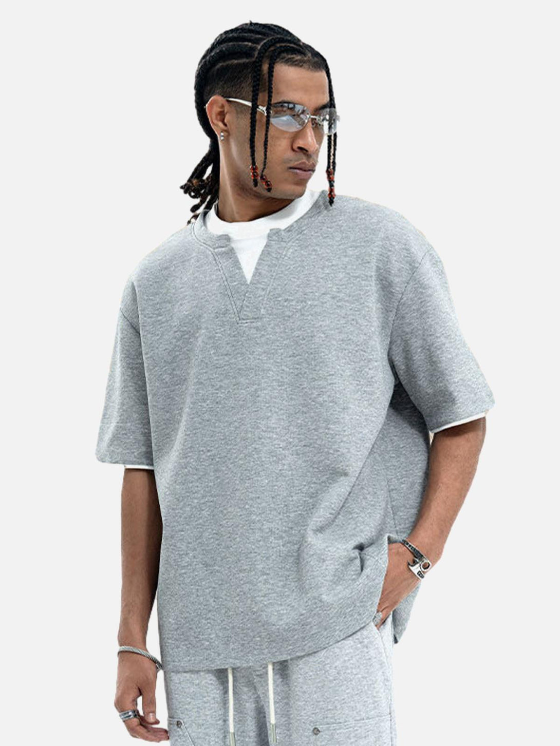 Model wearing a gray TALISHKO oversized t-shirt with layered faux design and casual fit.