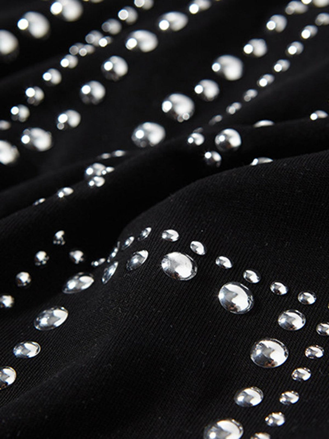 "TALISHKO vest fabric, highlighting intricate studded detailing on black material."