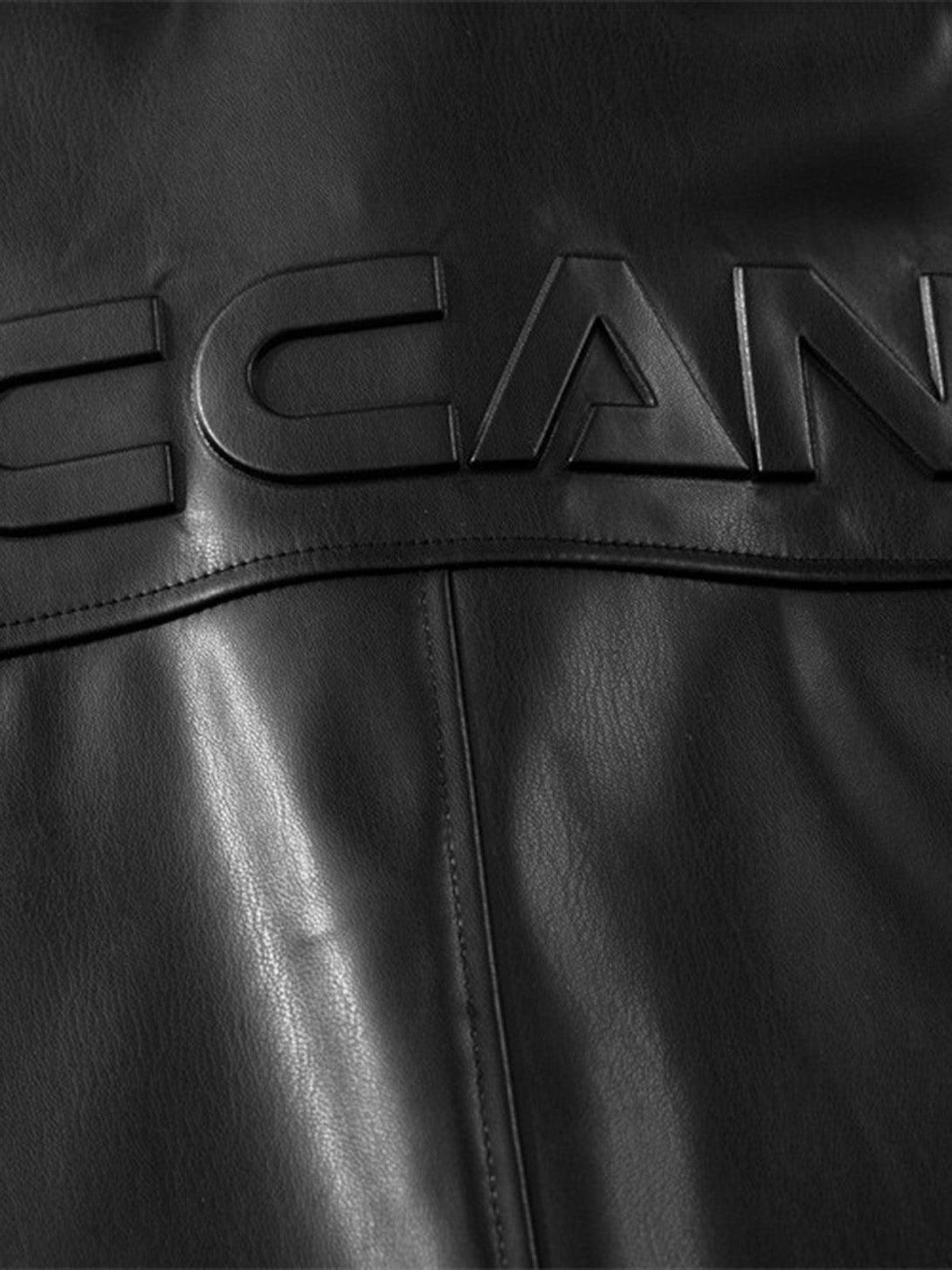 Detailed view of TALISHKO's black PU leather shirt, focusing on the embossed lettering.