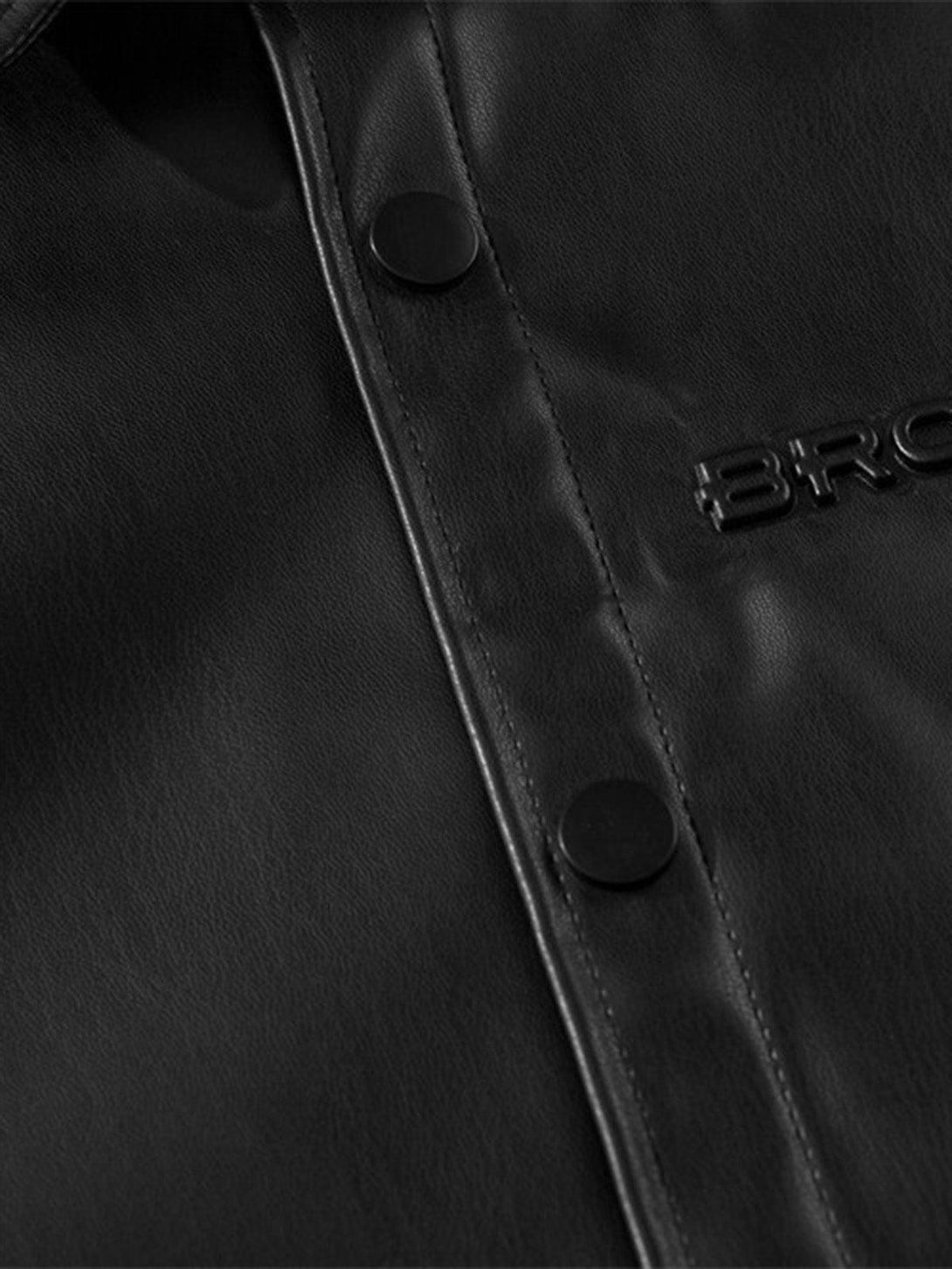 Zoomed-in texture of TALISHKO's black PU leather shirt, featuring button detail.