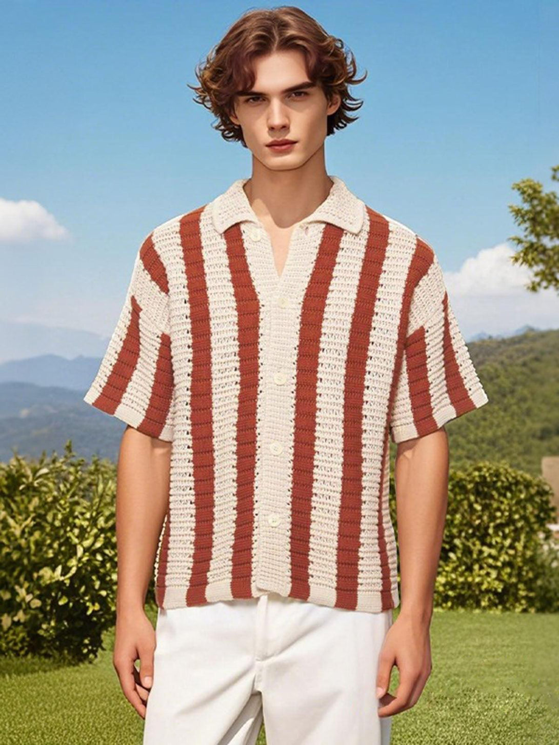 Model in a striped knit cardigan shirt by TALISHKO, set against a scenic outdoor backdrop.