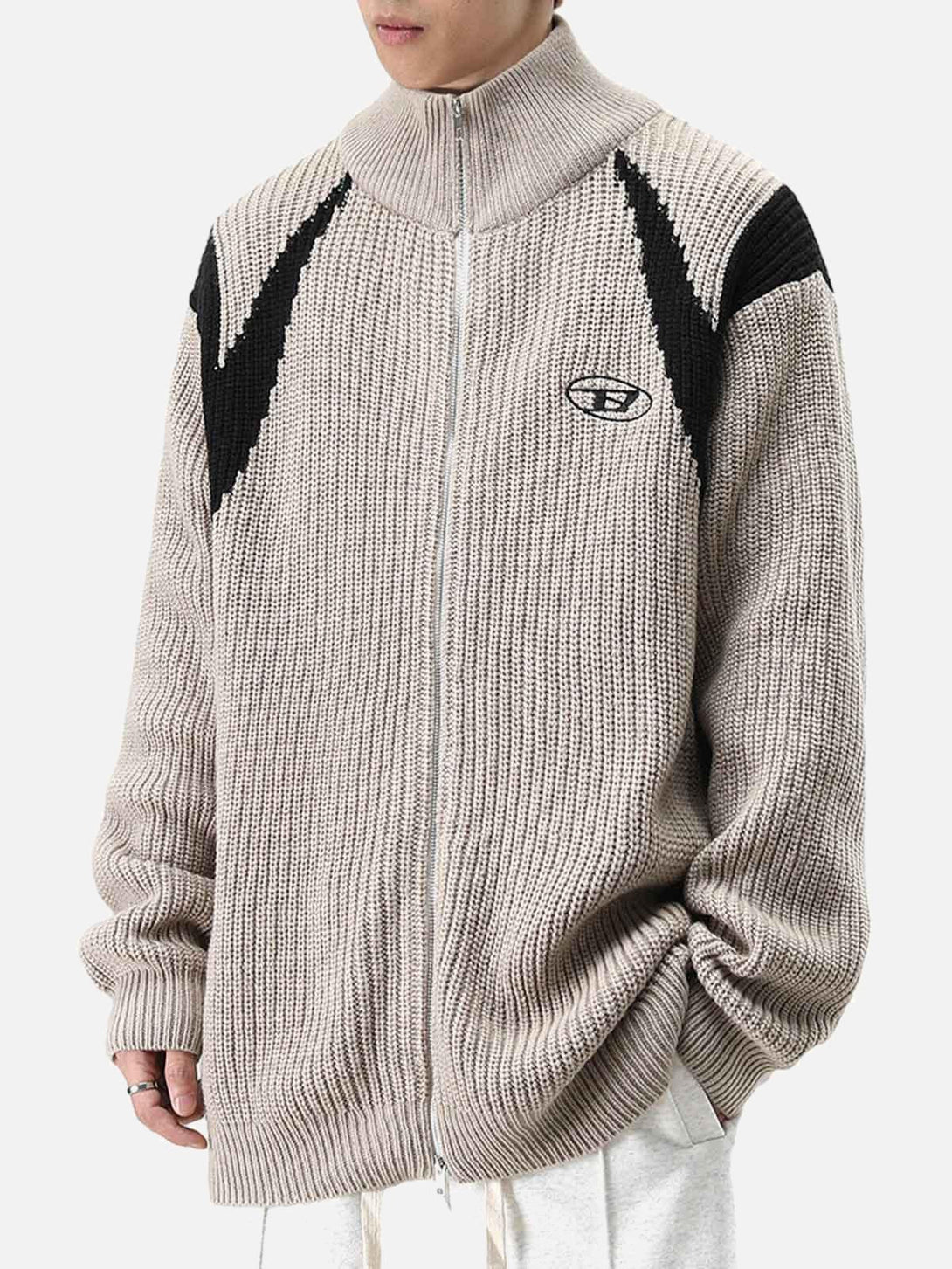 Model wearing a TALISHKO color block zipper sweater jacket, highlighting its textured knit design.