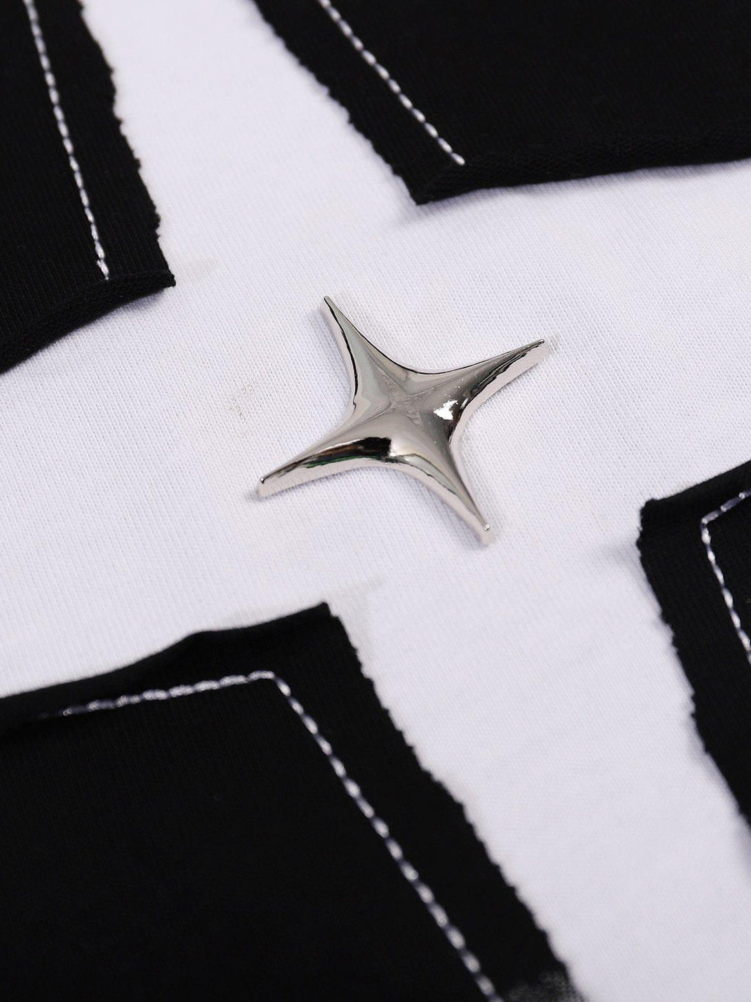 A detailed view of TALISHKO's star tee, highlighting its silver star design and contrast stitching.