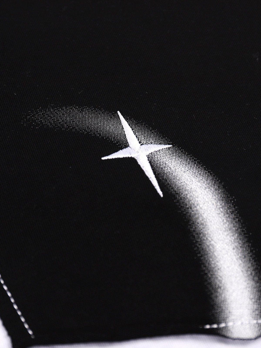 Zoomed-in detail of TALISHKO's star tee, highlighting the intricate silver star design.