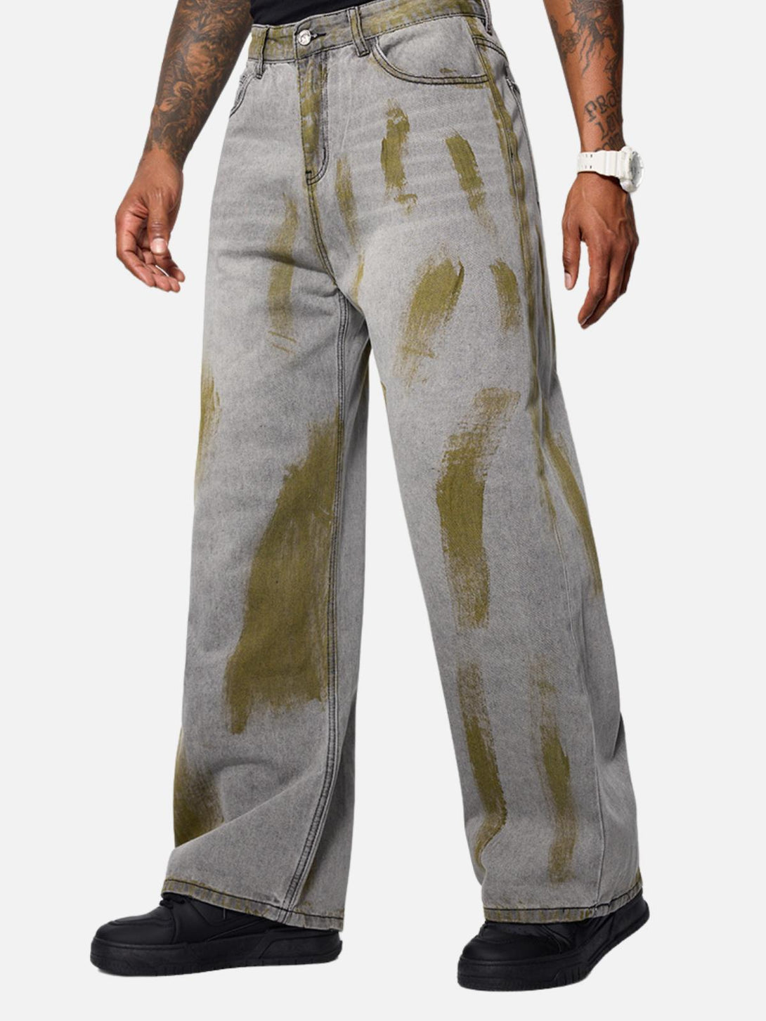 Model showcases TALISHKO's gray loose jeans with unique color blocking and relaxed fit.