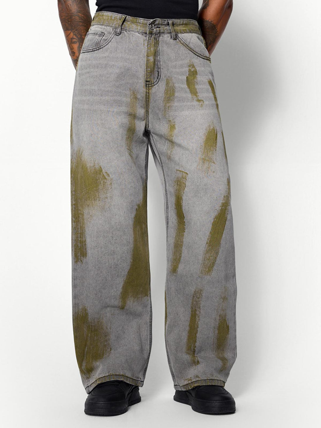 Model sporting TALISHKO's loose jeans with distinct color blocking for a trendy streetwear look.