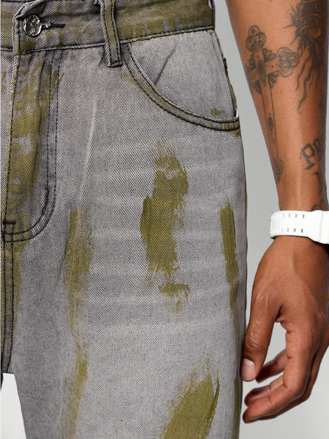 Zoomed-in detail of TALISHKO's loose jeans, showcasing unique color blocking and street style.