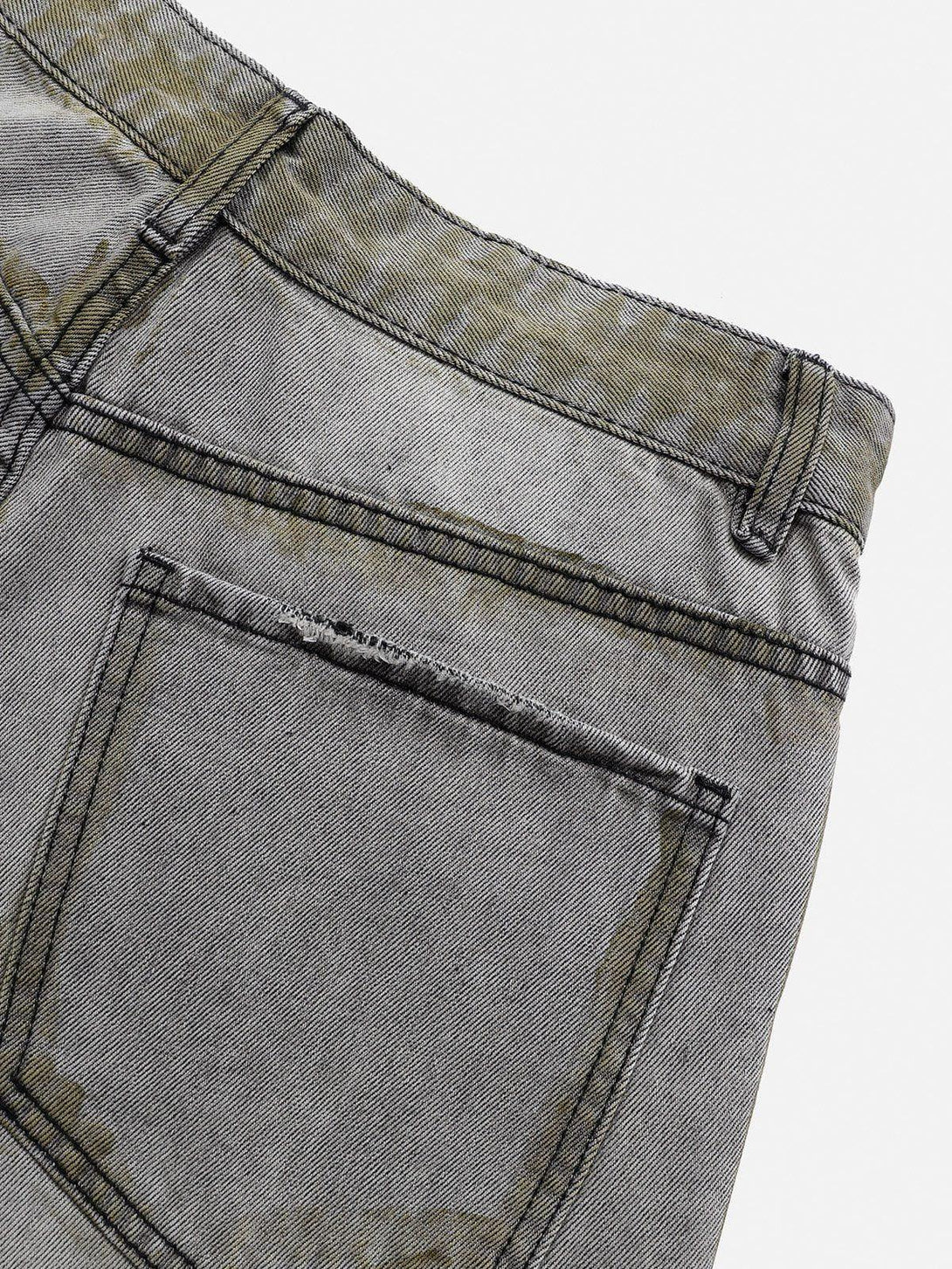 Detailed view of TALISHKO's loose jeans, highlighting the unique color blocking design.