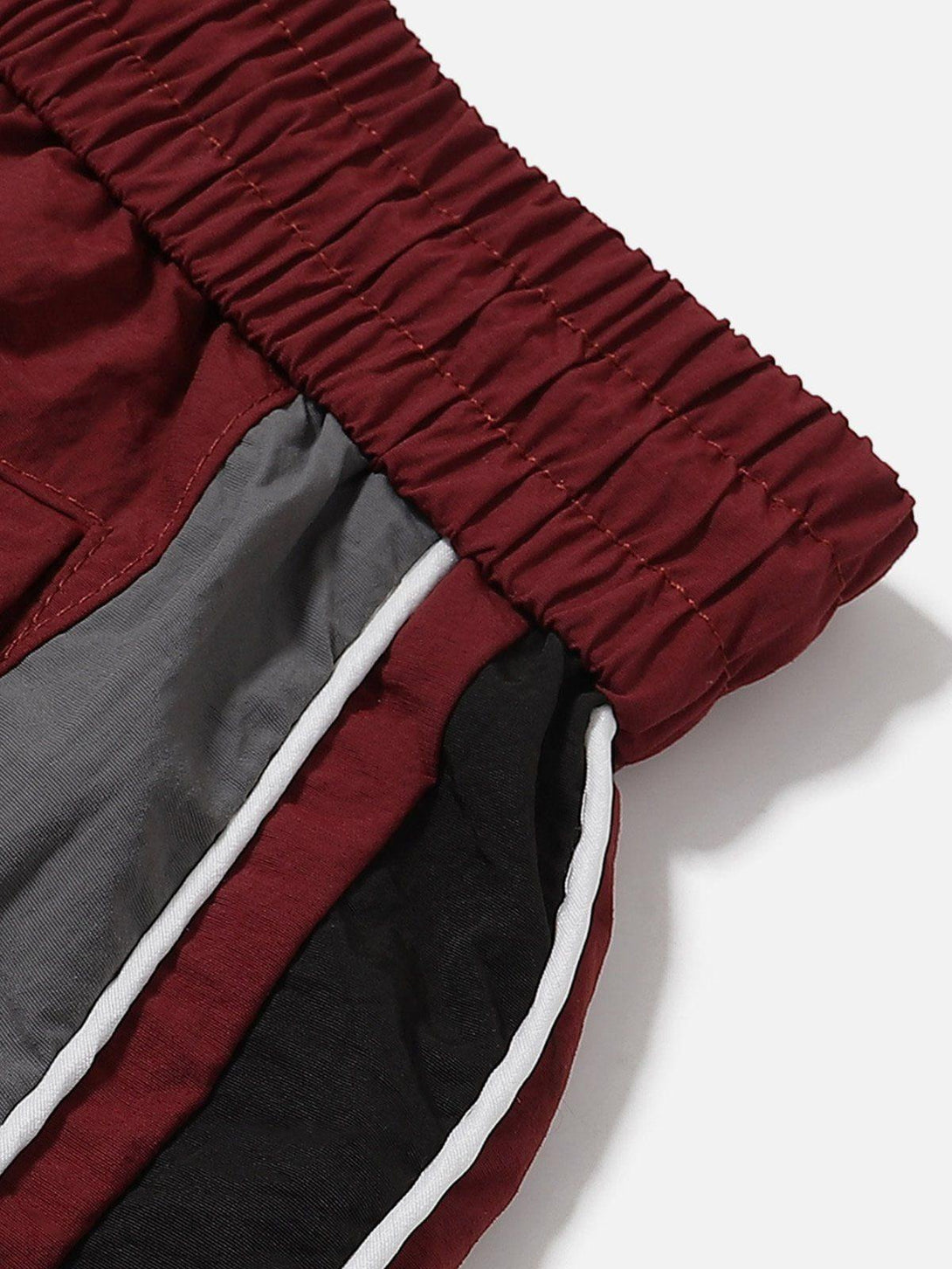 Detailed view of TALISHKO color-blocking patchwork shorts with elastic waistband.
