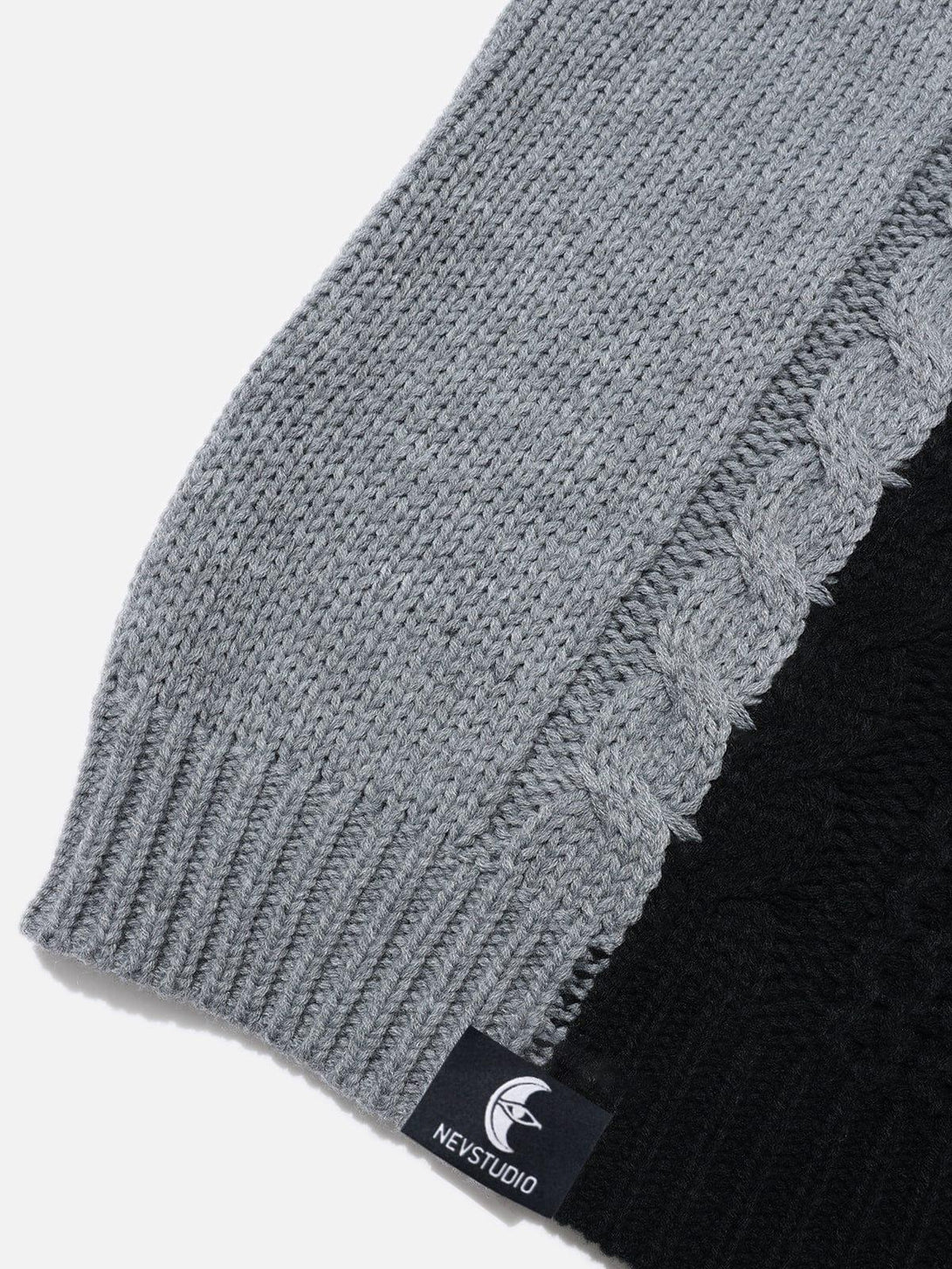 Focusing on the intricate cable knit and color-block design of TALISHKO's patchwork sweater.