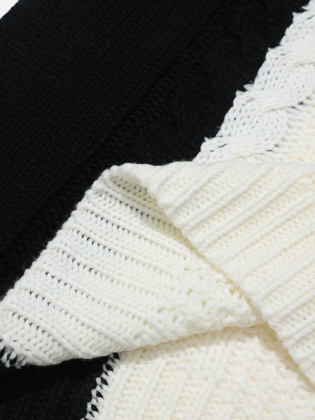 Intricate look at the black and white color-block design of TALISHKO's patchwork sweater.