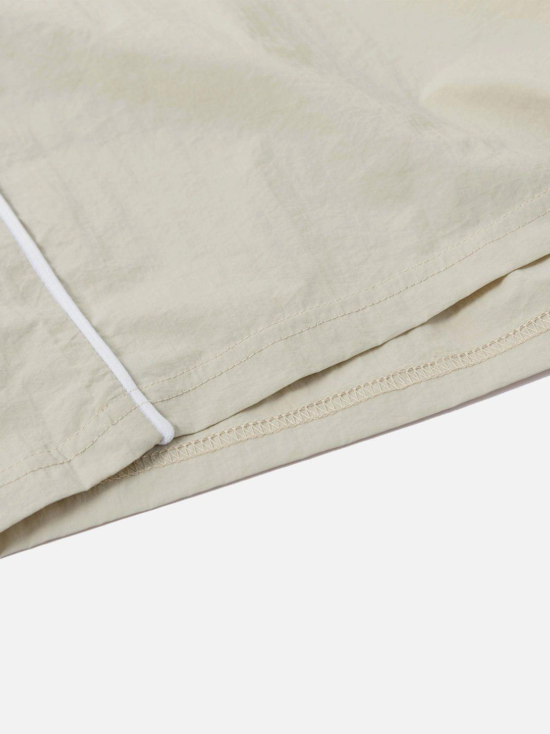 Intricate look at TALISHKO color blocking shorts, highlighting subtle stitching and texture.