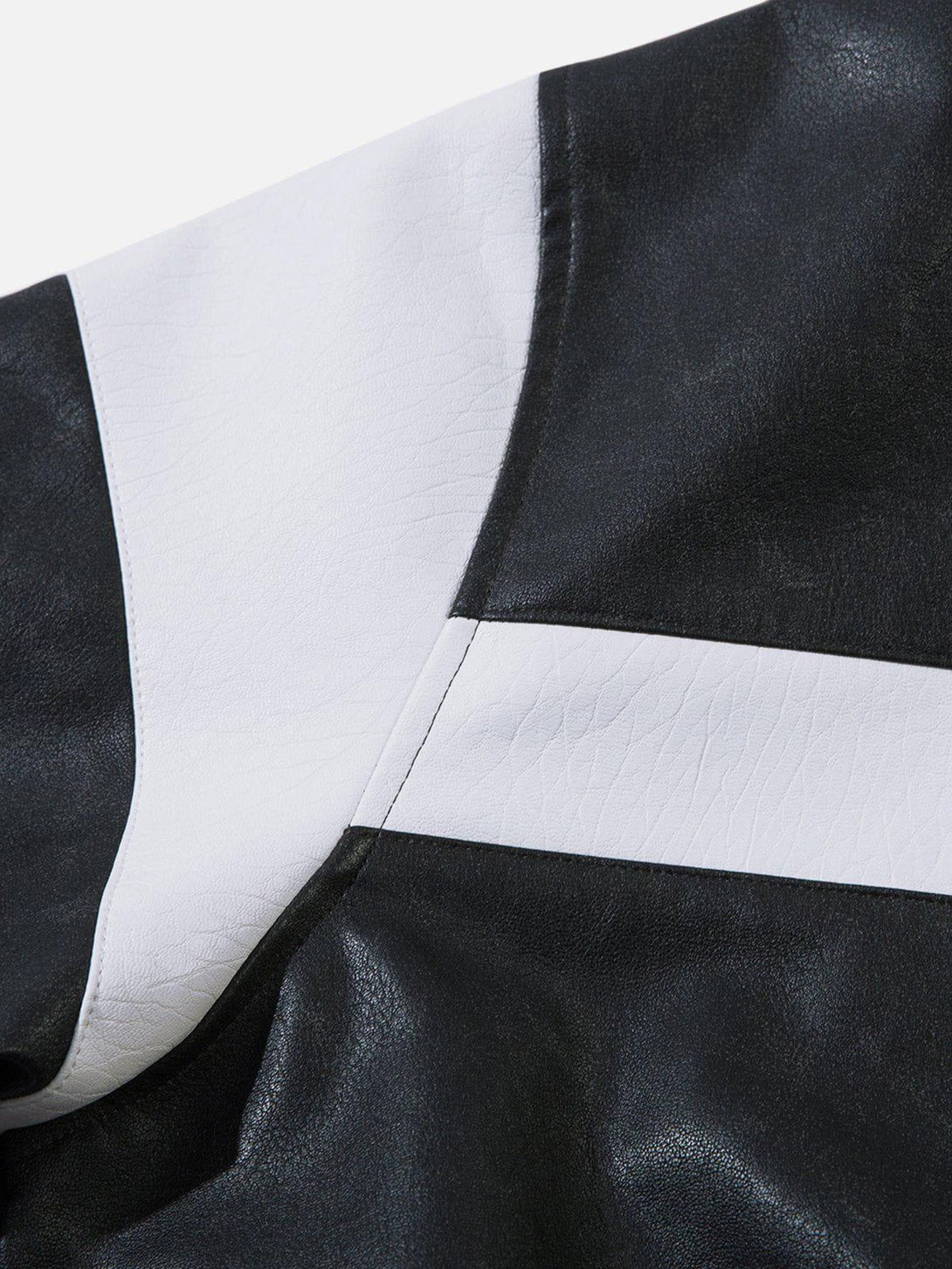 A tight crop highlighting the black and white color-blocking stripes on TALISHKO's faux leather jacket.